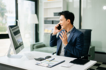 Asian businessman are delighted and happy with the work they do on their tablet, laptop and taking...
