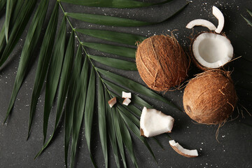 Fresh coconuts and palm leaf on black background