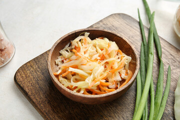 Bowl of tasty sauerkraut and green onion on white background. Closeup