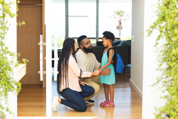 Preparing for school, Happy parents helping daughter with love and support, at home