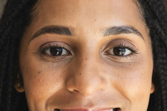 Smiling woman with braided hair showing joyful expression, at home
