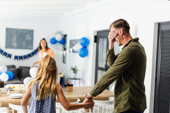Father surprised by daughter at home birthday party with decorations and balloons