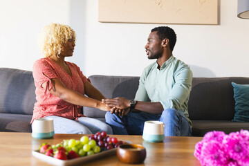 Holding hands, African American friends sharing supportive conversation on sofa, copy space