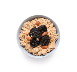 Bowl of tasty oatmeal with prunes and almonds on white background