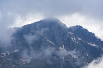 Misty rocky mountain under clouds.........