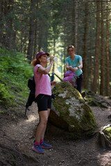 Women resting on forest hiking trail..