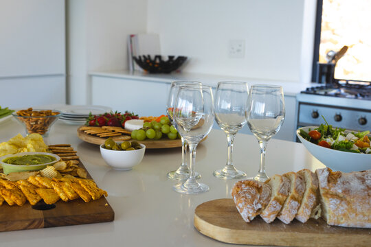 Fototapeta Elegant table setting with wine glasses, fresh bread, and assorted appetizers