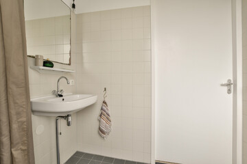 A sleek, contemporary bathroom design featuring a clean sink area with a stylish mirror and minimalist decor. The neutral tones enhance the spacious feel.