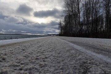 snow covered melted snow on an asphalt road in winter