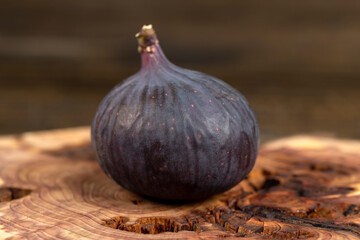 one purple figs on a juniper board, ripe fig fruit on the kitchen table before cooking