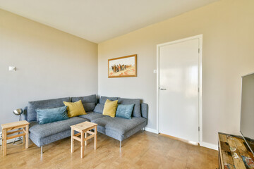 A stylish modern living room featuring a cozy sofa, decorative pillows, and light wooden flooring, creating a welcoming atmosphere.