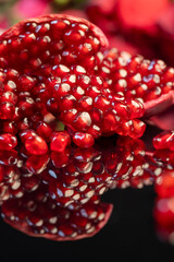 peeled ripe red pomegranate with juicy grains, closeup, side view