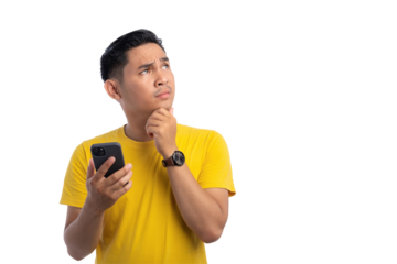 Pensive handsome Asian man holding mobile phone, touching his chin, looking at copy space, thinking about online offer isolated on transparent background