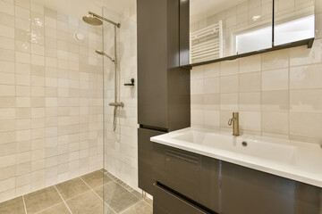 A sleek and contemporary bathroom featuring minimalist design elements, a glass shower enclosure, and a stylish sink area with storage.