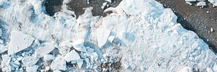 Top view of the ice floes on the shore. White ice on the sea beach. Wide panoramic background.