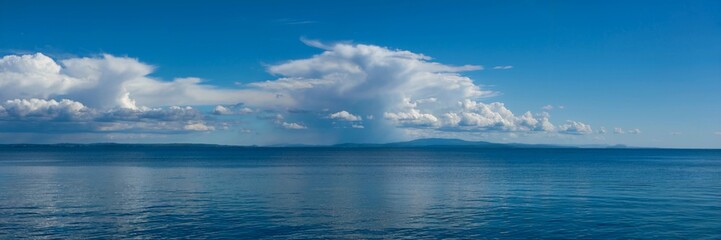 Naklejka premium Blue sea landscape with perfectly aligned horizon with blue sky and white clouds
