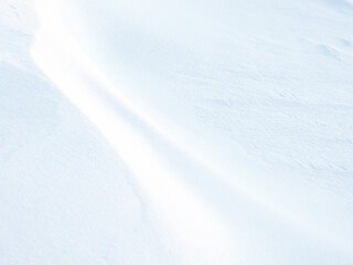 Beautiful winter background with snowy ground. Natural snow texture. Wind sculpted patterns on snow...