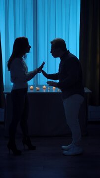 Silhouette of Two People Arguing in Dimly Lit Room