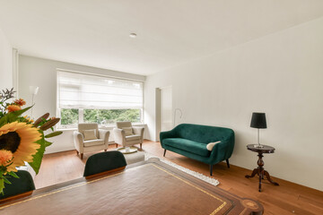 A stylish interior featuring a green sofa, wooden table, and sunflowers, with ample natural light spilling through the window, creating a welcoming atmosphere.