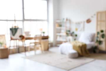 Blurred view of teenager's room with bed, workplace and easel