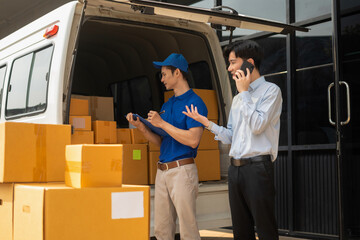 Asian man signs for parcel delivery, confirming shipment. Concept of e-commerce, logistics, and...
