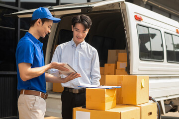 Asian man signs for parcel delivery, confirming shipment. Concept of e-commerce, logistics, and...