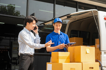 Asian man signs for parcel delivery, confirming shipment. Concept of e-commerce, logistics, and...
