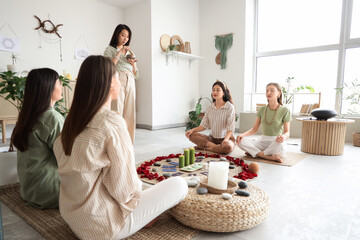 Group of young women with Tibetan singing bowl meditating in circle