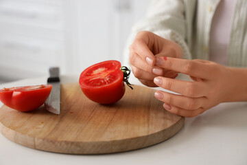 Young woman with cut finger in kitchen, closeup