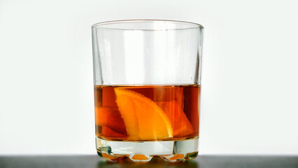 A nice glass of whiskey or rum with lemon against white background close-up