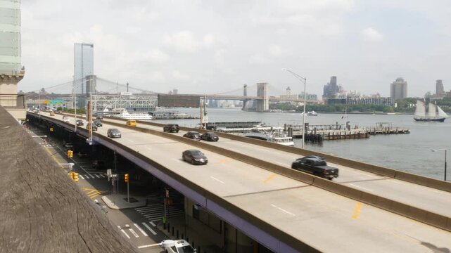 New York City waterfront road, Financial district, Manhattan Downtown riverfront from Elevated Acre. Highway along East river, cars on waterside FDR drive, yellow taxi. Brooklyn Bridge, United States.