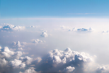 Fototapeta premium Background beautiful white dramatic clouds in a blue sky. Top view from an airplane. Fantastically beautiful fabulous view of the sky.