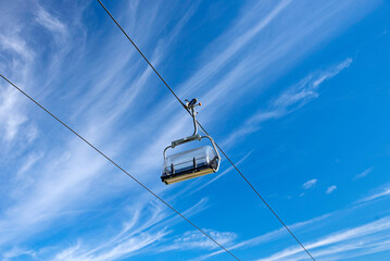 Empty Chairlift Against Blue Sky – Summer Alpine Transport in the Mountains