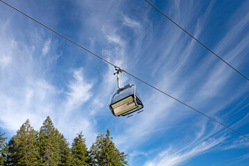 Empty Chairlift Against Blue Sky – Summer Alpine Transport in the Mountains