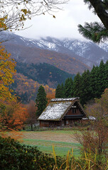 Fototapeta premium Ancient house with green trees and meadows in front of the mountain.