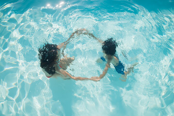 abstract art with young girl and boy swimming in the pool under water surface