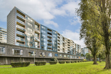 A sleek, contemporary residential building surrounded by lush greenery and a clear blue sky, showcasing modern architectural design.