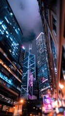 Obraz premium Low angle view of illuminated skyscrapers at night in a bustling city