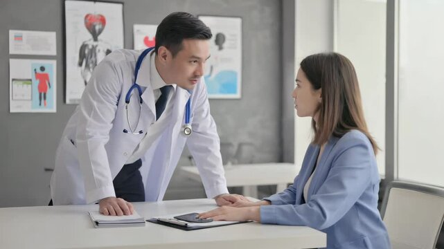 Arzt im Gespr&auml;ch mit Patientin in moderner Praxis


