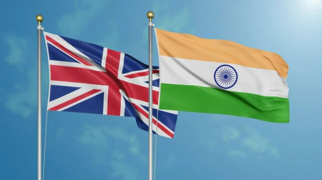 United Kingdom and India flags waving against a blue sky  