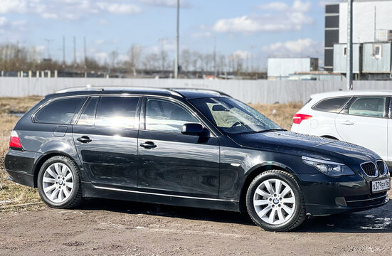 BMW E61 5-series in the city street. Black BMW Car model 5 series E61 station wagon in the center of the town. The LED optics of the station wagon's taillights. 