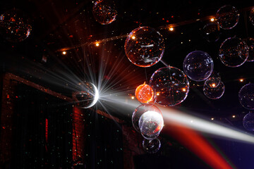A room with a disco ball and many colorful balloons.