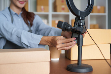 Entrepreneurship and Equipment Setup. A businesswoman sets up her filming equipment to enhance her online sales presentations.
