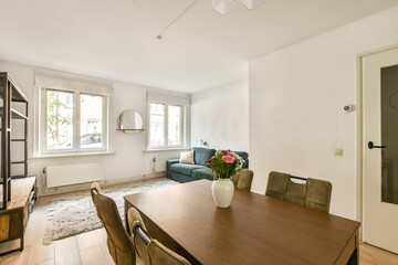 Bright and airy modern interior featuring a wooden dining table, stylish chairs, and minimalist decor elements creating a warm and inviting atmosphere.