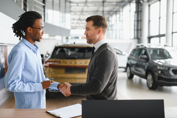 A consultant at a car dealership helps a customer choose a new car