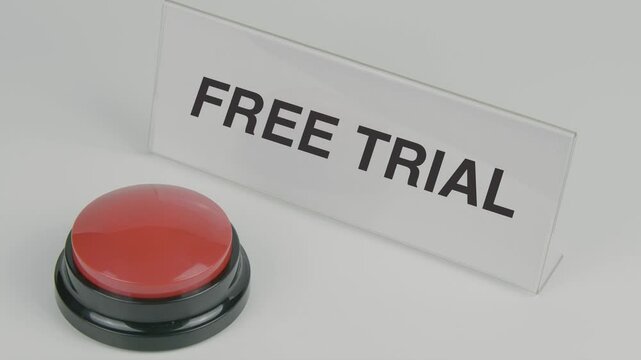 "Free Trial" text or word displayed on a nameplate as a hand presses a red button, set against a white background, symbolizing a promotional offer or temporary access to a service