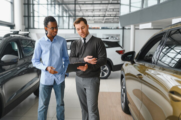 A consultant at a car dealership helps a customer choose a new car