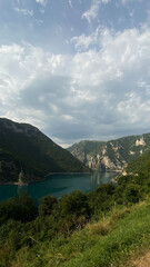 Fototapeta premium Scenic view of a lake surrounded by mountains under a cloudy sky