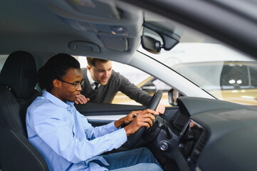A consultant at a car dealership helps a customer choose a new car