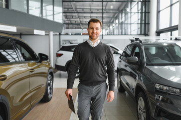 car dealer principal standing in showroom